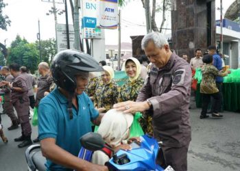 Kajati Sumut Idianto, SH,MH memberikan takjil kepada seorang pengguna jalan di depan kantor Kejati Sumut, Jalan AH Nasution Medan, Kamis (20/3/2025).