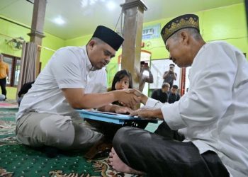 Gubernur Sumut Bobby Nasution beserta keluarga menyerahkan Zakat Fitrah 1446 H di Masjid Al Furqan, Desa Saentis, Kecamatan Percut Seituan, Kabupaten Deliserdang, Minggu (30/3/2025). Foto/Diskominfo Sumut
