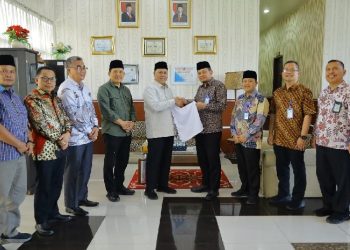 Plt Dirut Perumda Tirtanadi, Ewin Putra menyerahkan menyerahkan handuk untuk Jemaah Haji Embarkasi Medan pada musim haji tahun 2025, di Asrama Haji Medan Jalan Jenderal Abdul Haris Nasution, Jumat (25/4/2025).
